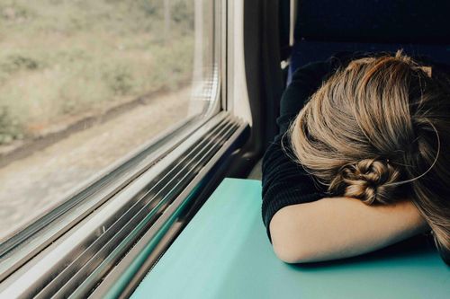 woman experiencing burnout on train