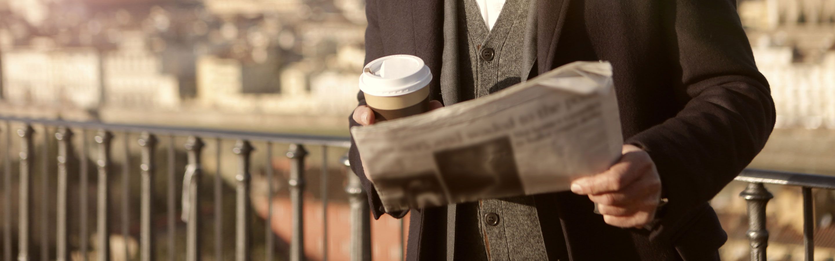 Journalist holding coffee and newsletter
