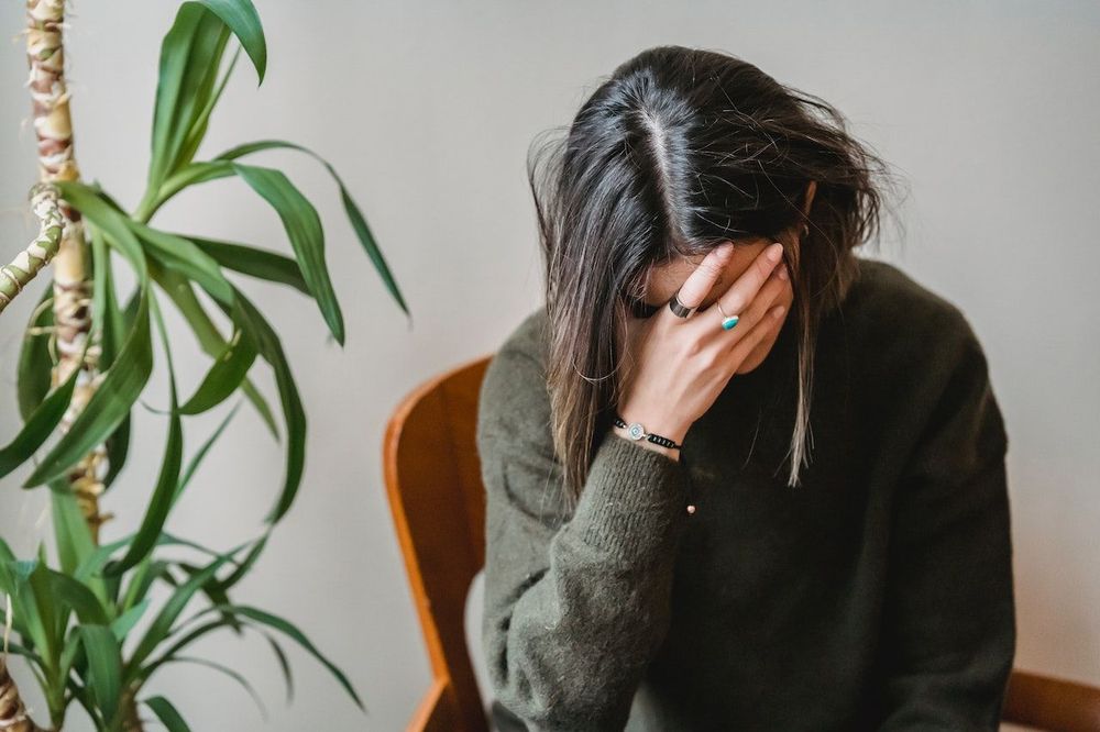 The woman is closing her face with the hand