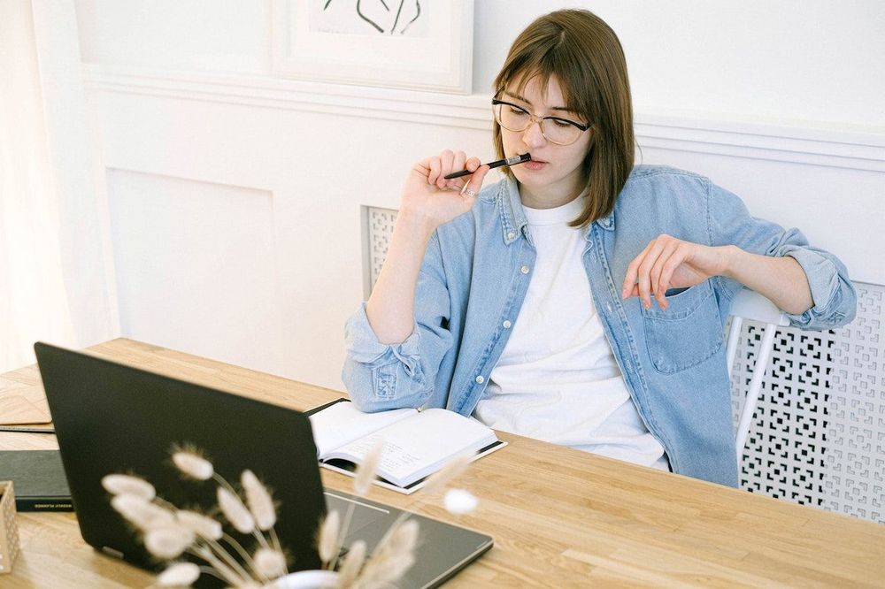 Freelance content creator sits in front of the laptop, and is thinking about blog post strategy 