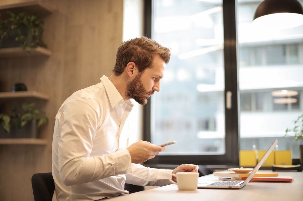 A freelancer man is drinking coffee and working on his brand at a workspace 