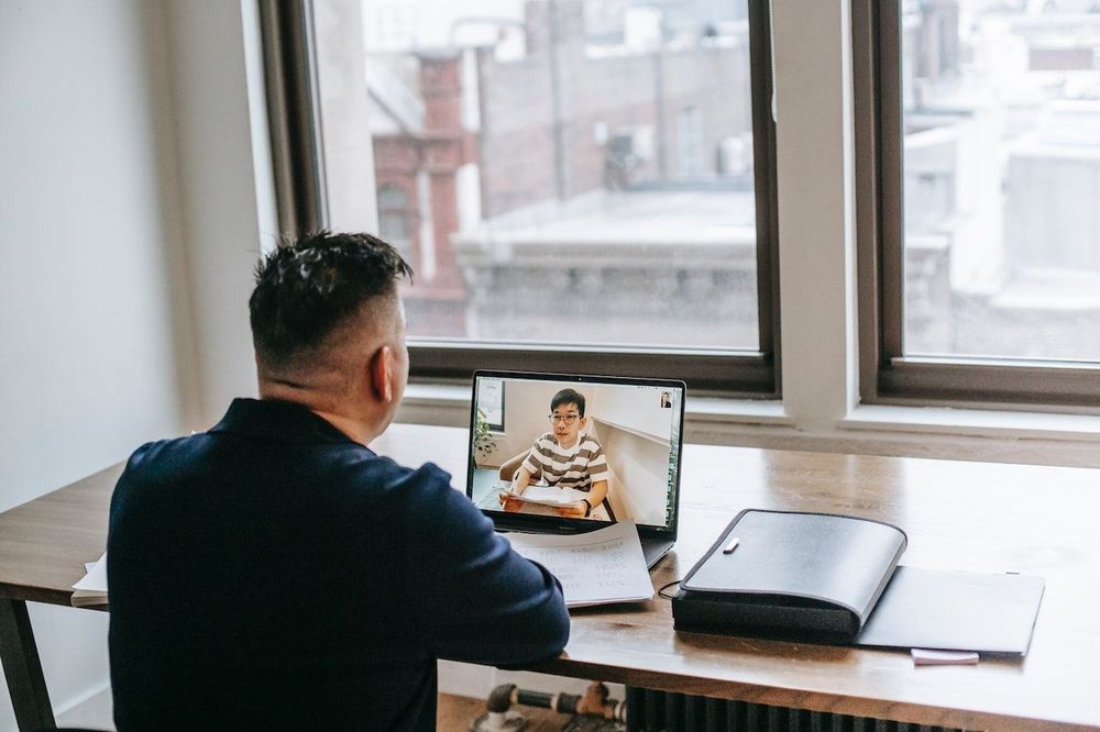 The freelance tutor is working with the help of laptop near the window