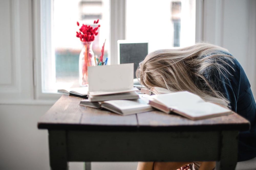 Freelancer is sleeping on the working table near the window