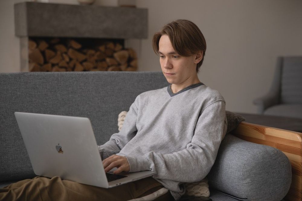 Freelancer is working from home on his sofa 