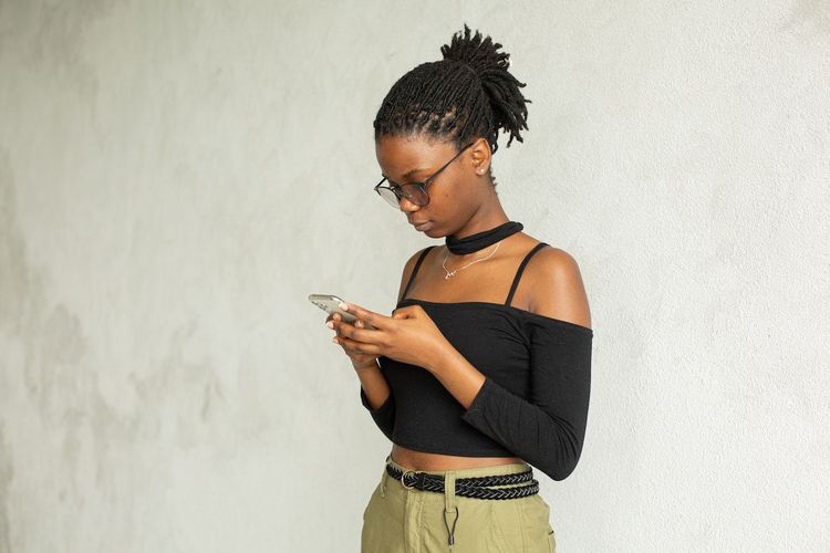 Freelancer is standing near the wall with the phone